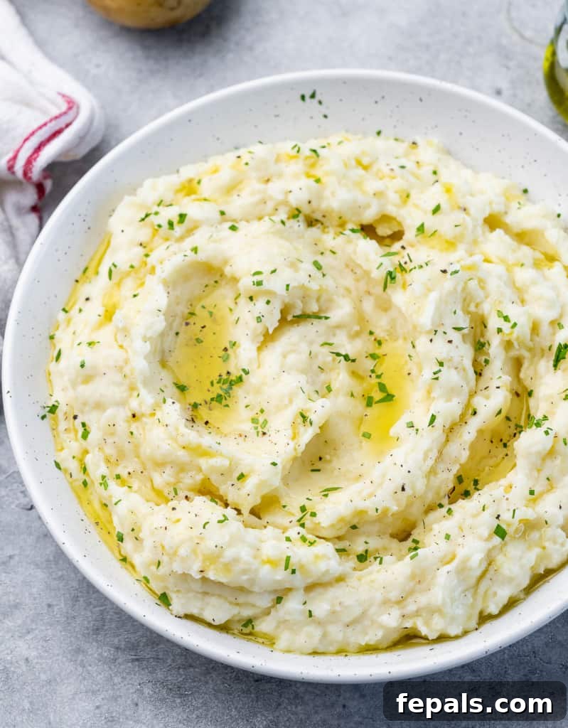 Vegan mashed potatoes garnished with parsley and served in a white bowl, ready to be enjoyed.