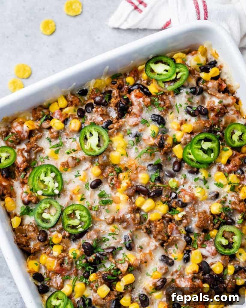 A whole taco casserole baked in a white rectangular baking dish, ready to be served.