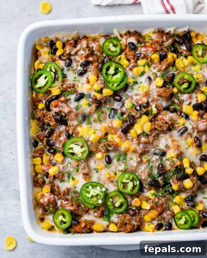 A close-up of a beefy casserole topped with melted cheese and sliced jalapeños, ready to be served.
