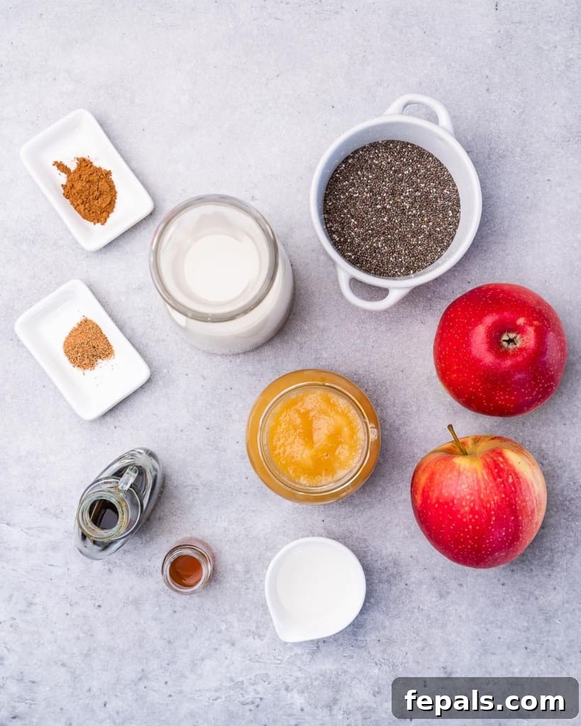 Spiced Apple Pie Chia Pudding 4 Ingredients laid out to make apple pie chia pudding, including apples, spices, milk, and chia seeds