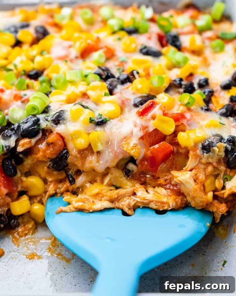 Serving chicken enchilada casserole with a spatula.