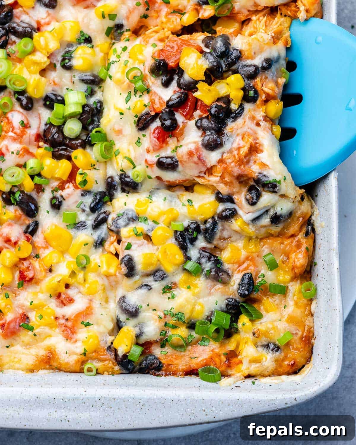 Using a spatula to serve enchilada casserole.