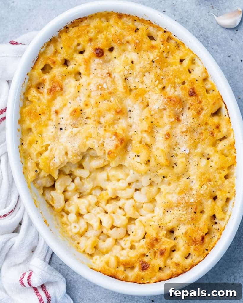 Baked macaroni and cheese in a white oval dish, ready to be served.