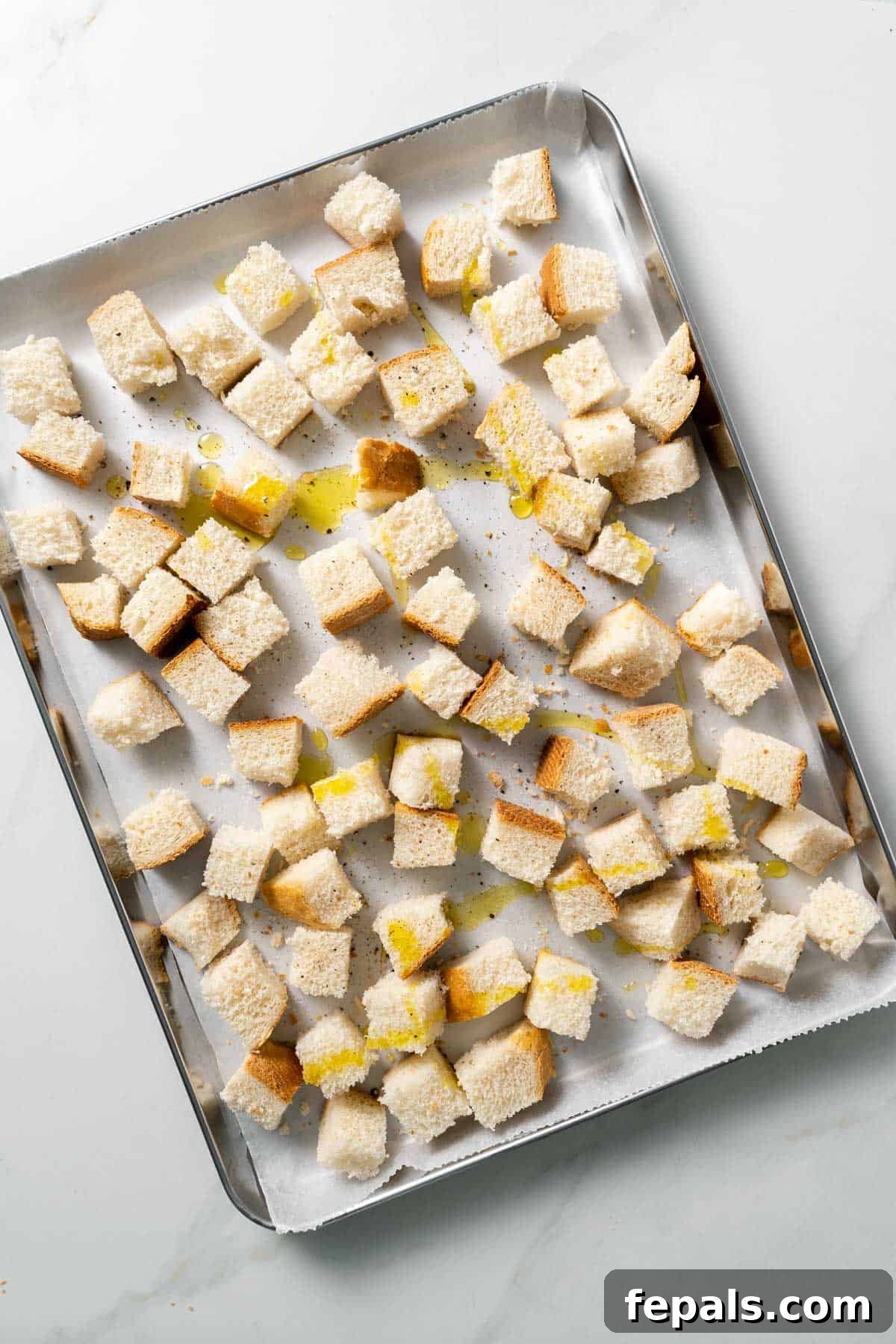 How To Make Croutons bread cubes tossed with olive oil atop baking sheet