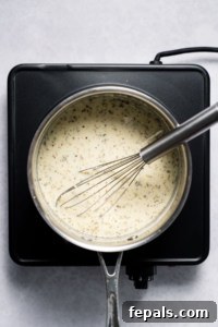 Whisking seasonings into healthy Alfredo Sauce in the pot.