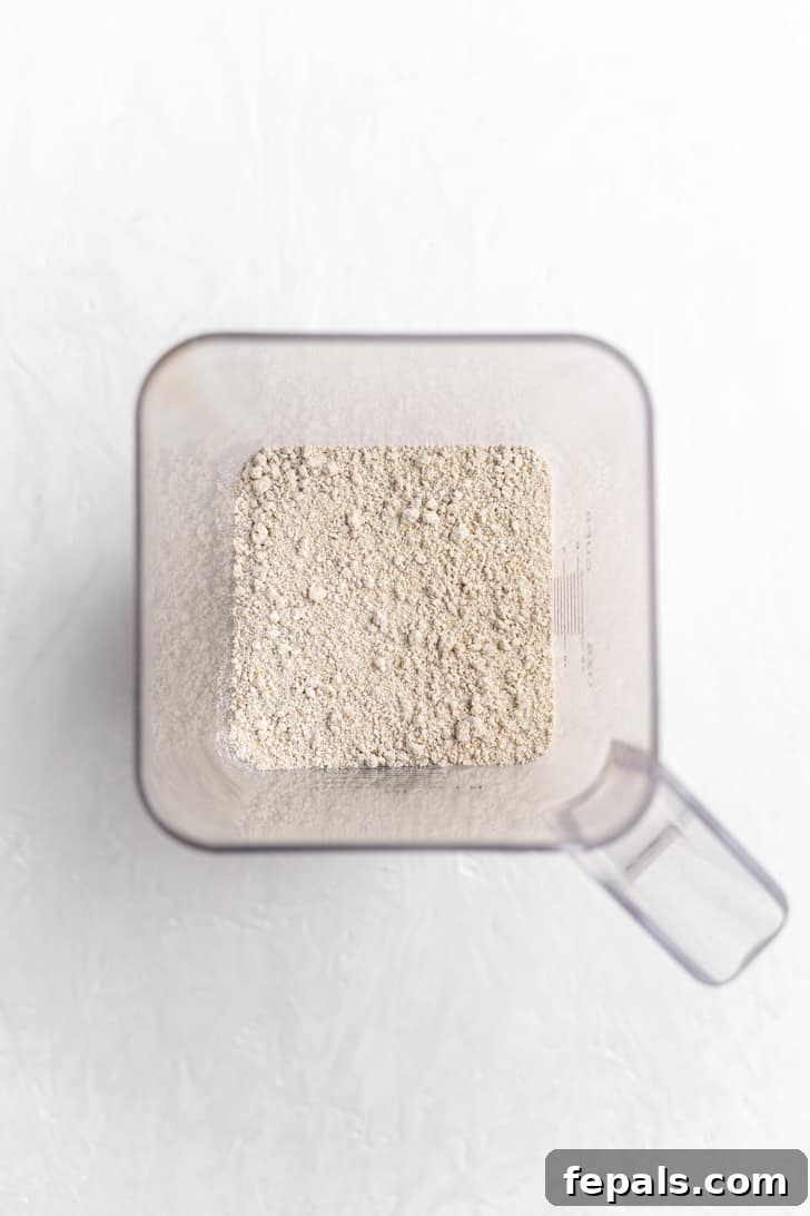 Finely ground oat flour inside a blender, demonstrating the powdery texture after blending.