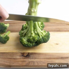 How to Perfectly Cut Broccoli 18 Knife cutting over broccoli stem.