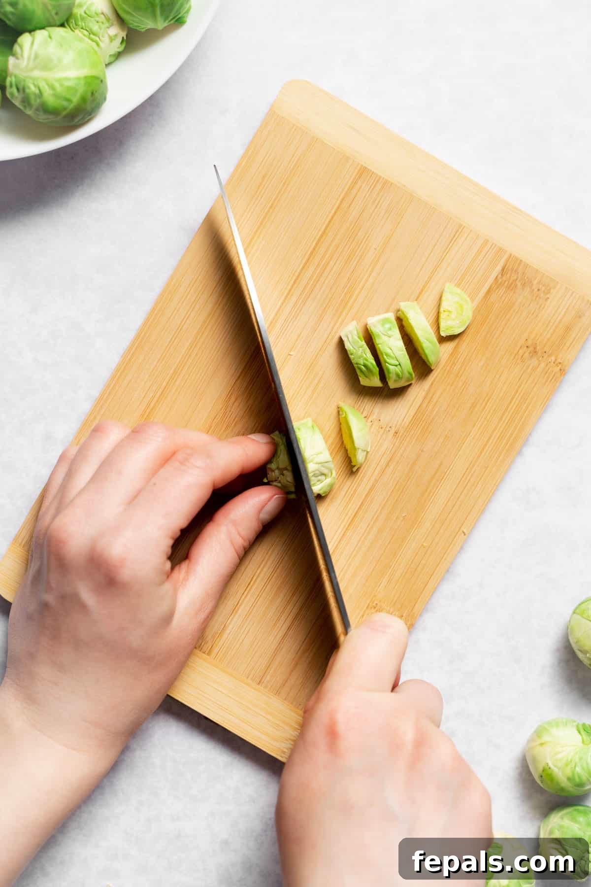 How To Cut Brussels Sprouts Using a knife to slice quartered Brussels sprouts into thin pieces