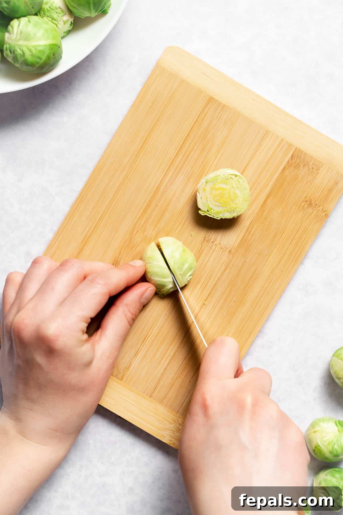 How To Cut Brussels Sprouts Slicing a halved Brussels sprout into quarters with a knife
