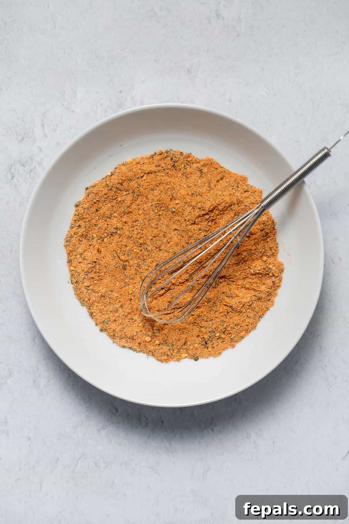 bowl of cajun seasoning with whisk