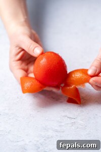 peeling a tomato with hands