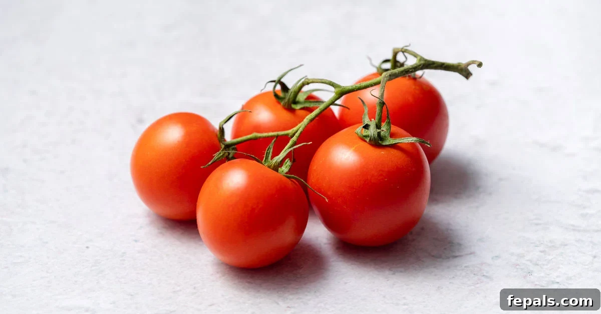The Simple Trick to Perfectly Peeled Tomatoes 10 A vibrant cluster of five ripe tomatoes still attached to their vine, symbolizing freshness and natural goodness.