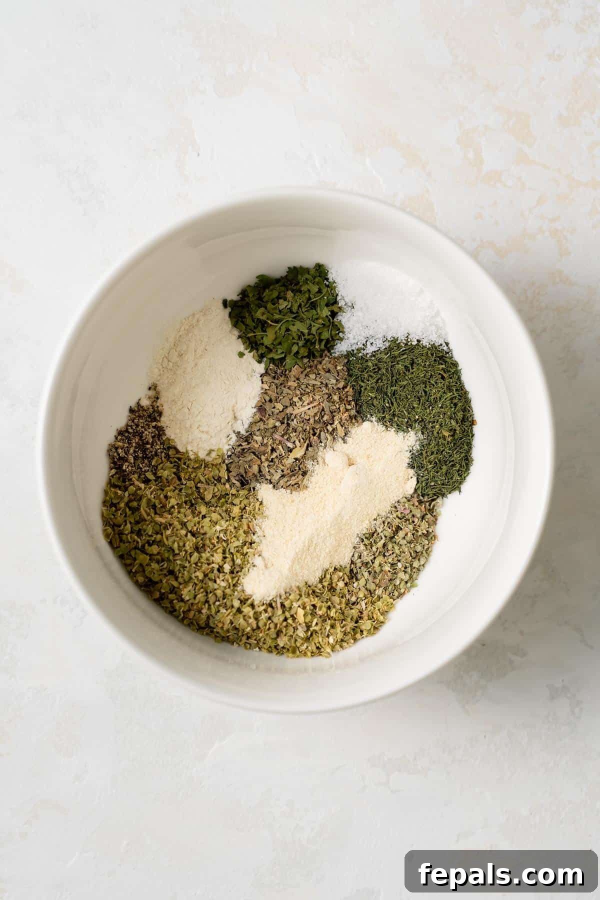 Greek spices and herbs in a shallow bowl before mixing