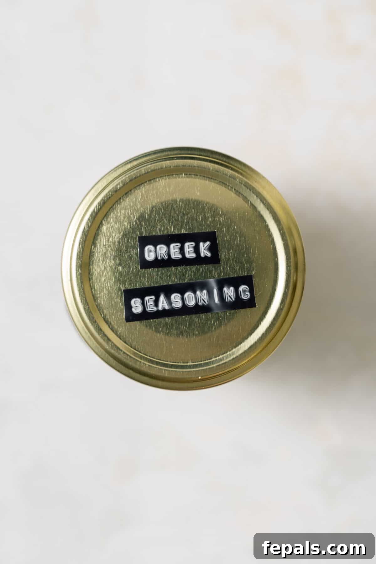 Top view of Greek seasoning in a jar with a rustic label, ready for storage