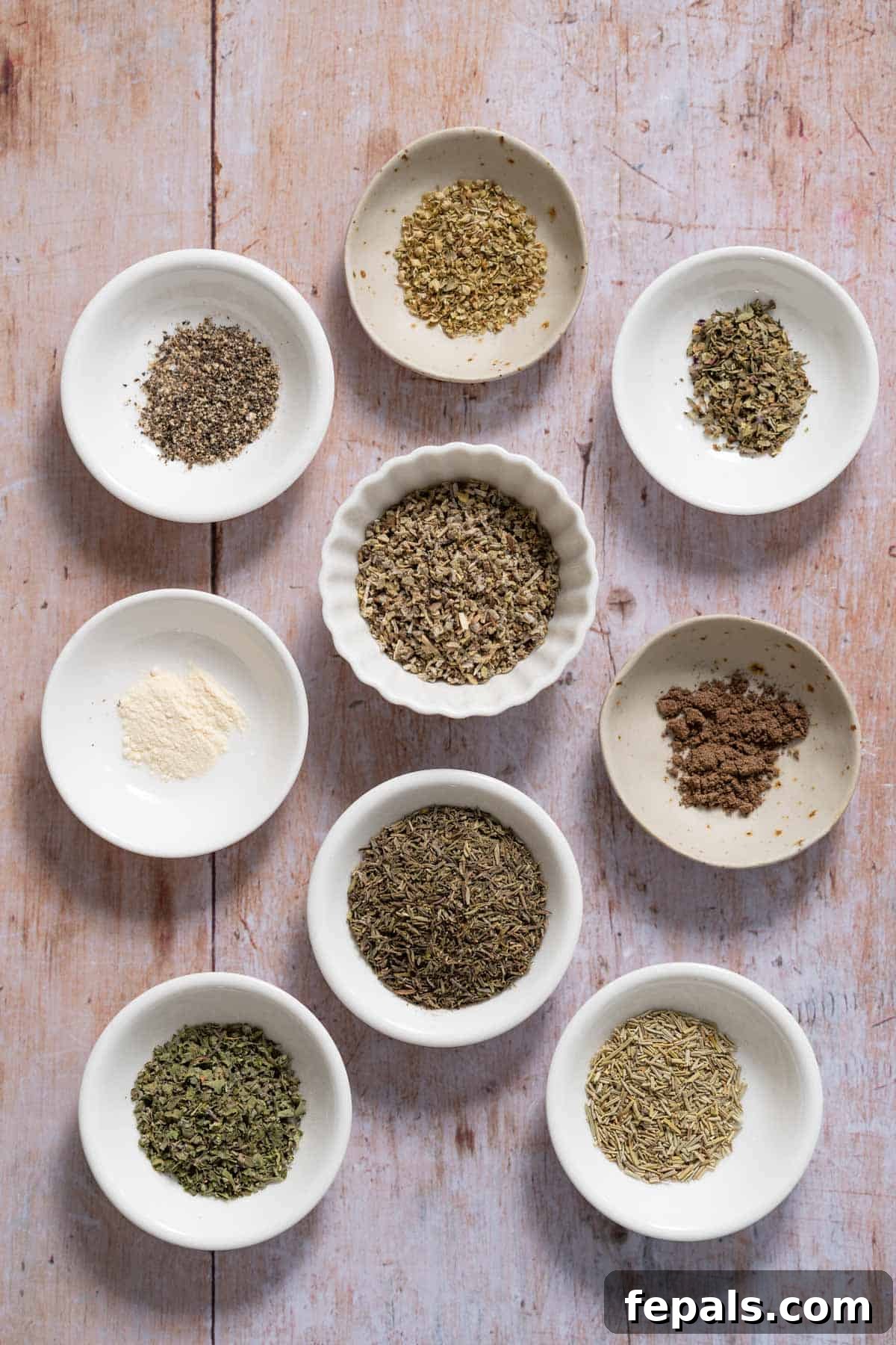Homemade Poultry Seasoning marjoram, garlic powder, thyme, basil, sage, black pepper, oregano, nutmeg, in containers for seasoning