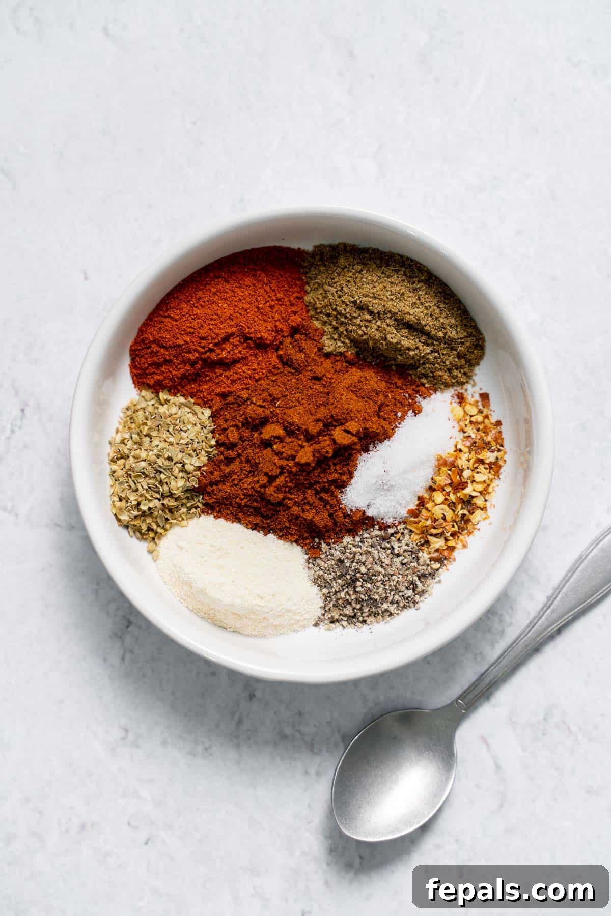 DIY Taco Seasoning chili powder, cumin, oregano, salt, chili flakes, pepper in bowl