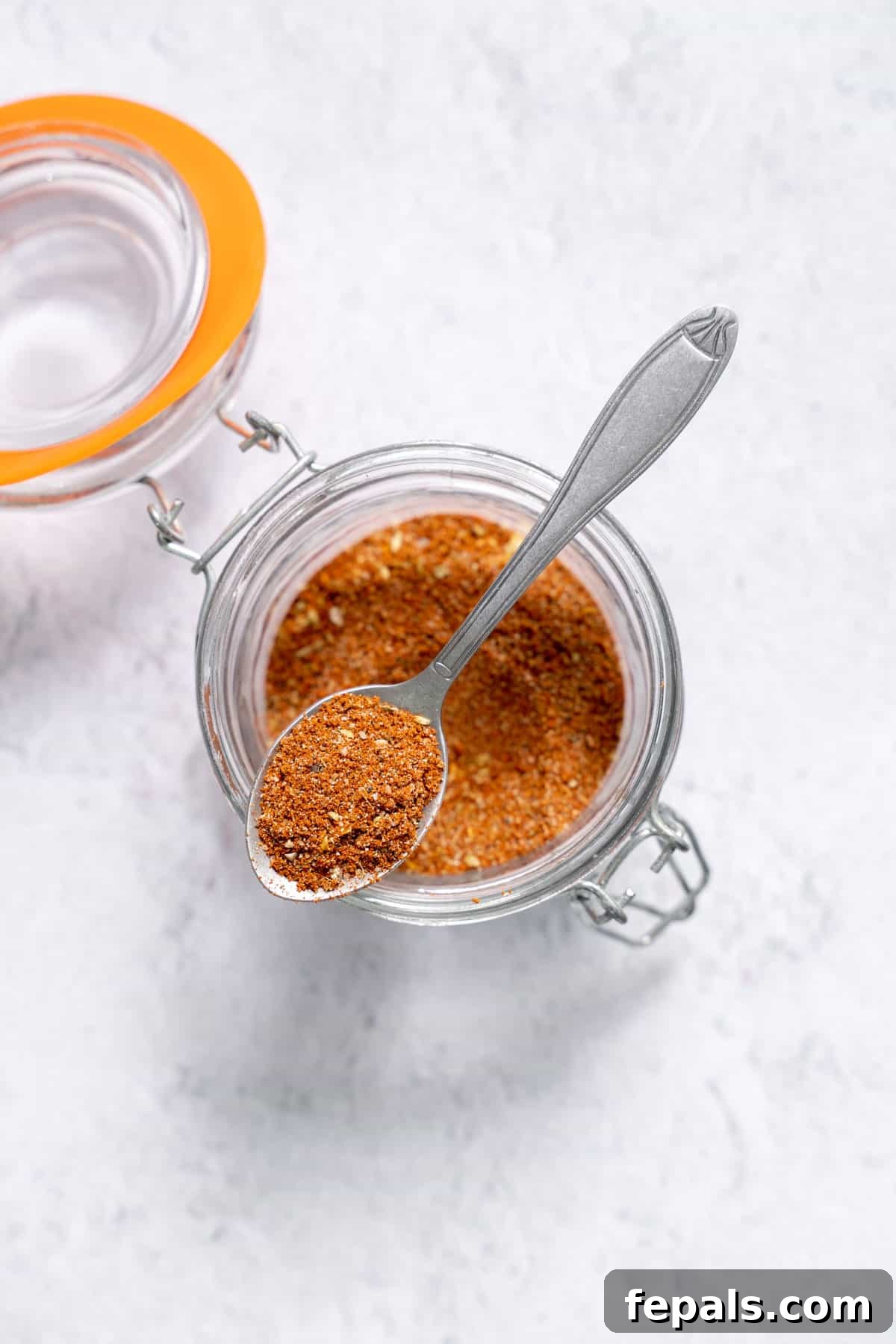Homemade Easy Taco Seasoning spoon resting atop jar filled with homemade taco seasoning