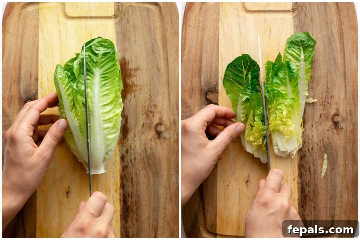 Process shot of slicing a romaine lettuce in half vertically on a cutting board with a sharp knife.