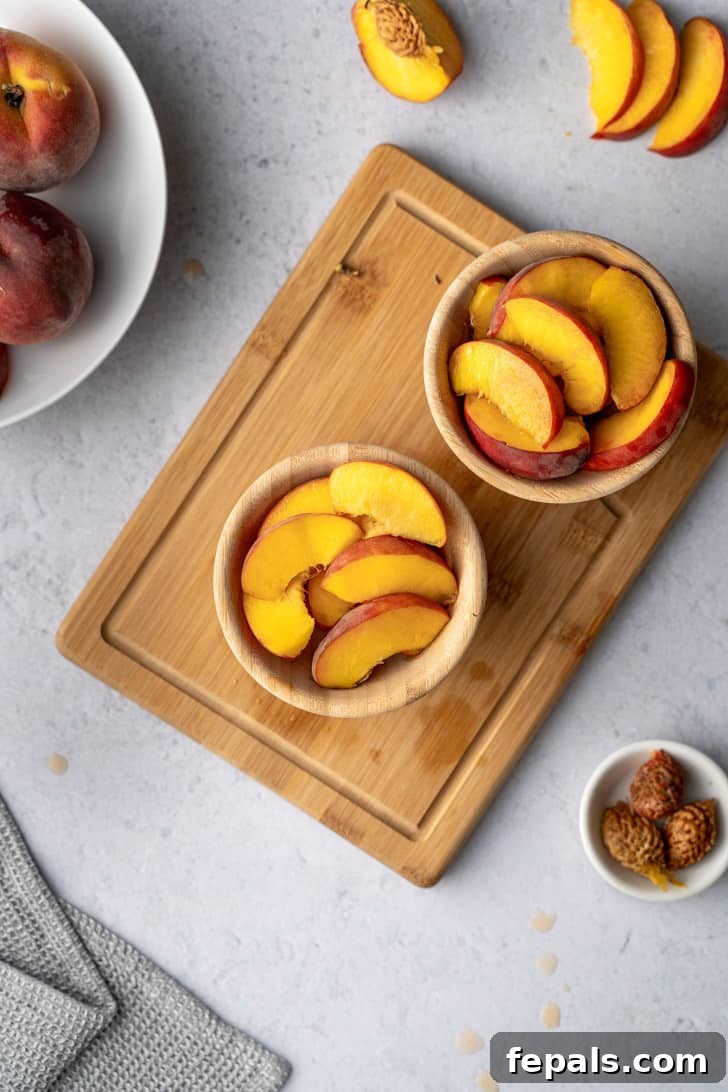 Sliced peaches neatly arranged in two bowls atop a wooden cutting board, ready for enjoyment or incorporation into delicious recipes.