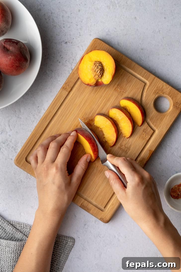 A sharp knife carefully slices through a peach on a cutting board, demonstrating precision and control in preparing the fruit.
