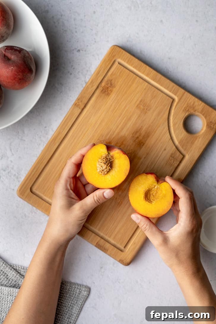 A close-up of a peach divided into two perfect halves, showcasing the fruit's texture and ripeness, ready for the next step of pit removal.