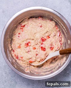 Wholesome Strawberry Muffins 14 Stirring strawberry batter in a large bowl.