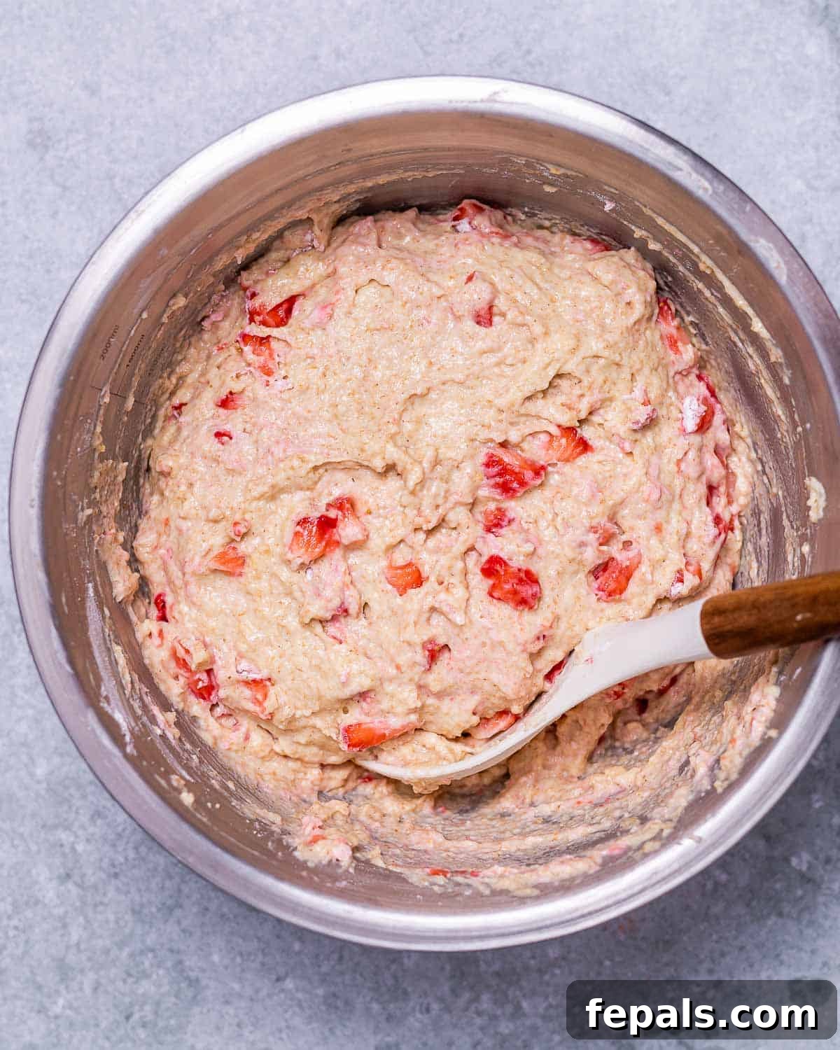 Wholesome Strawberry Muffins 6 Stirring strawberry batter in a large bowl, showing the combined wet and dry ingredients.