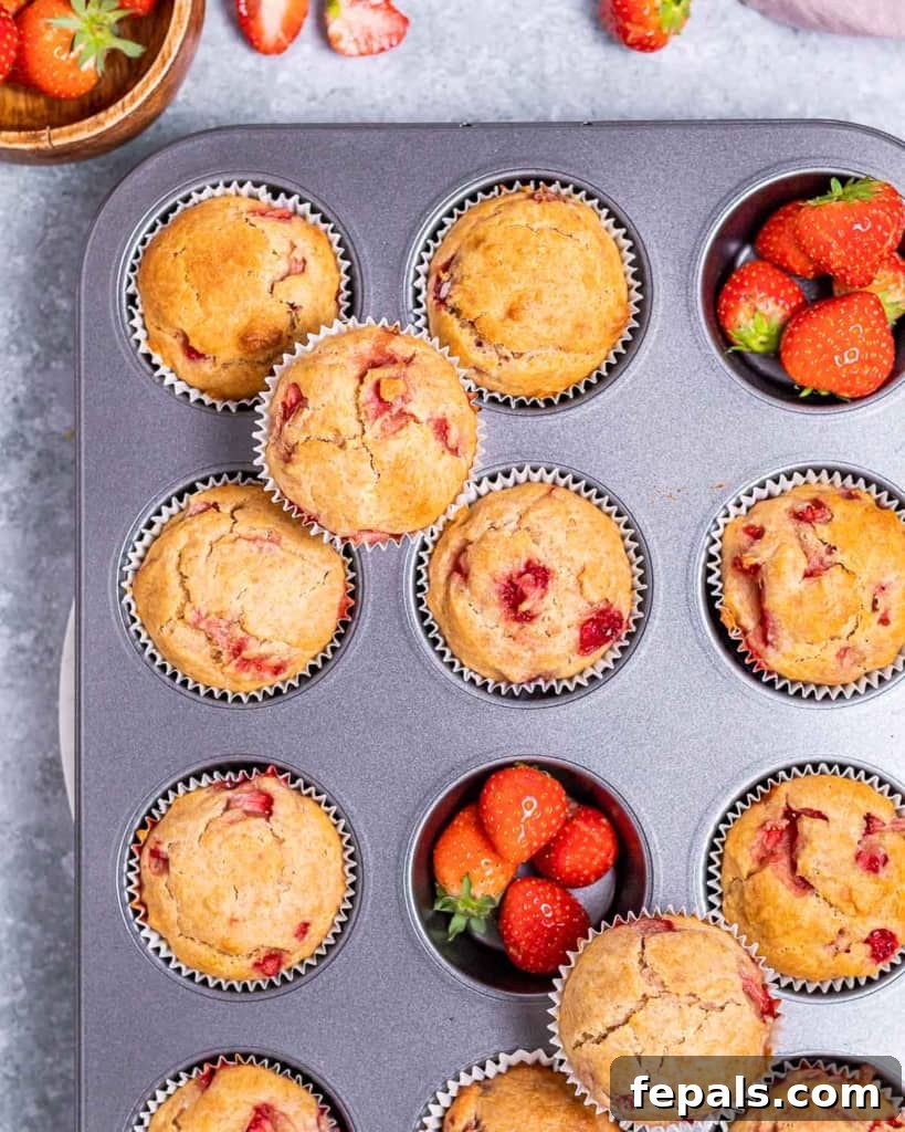 Wholesome Strawberry Muffins 7 Muffins made with strawberries, still hot in the muffin pan.