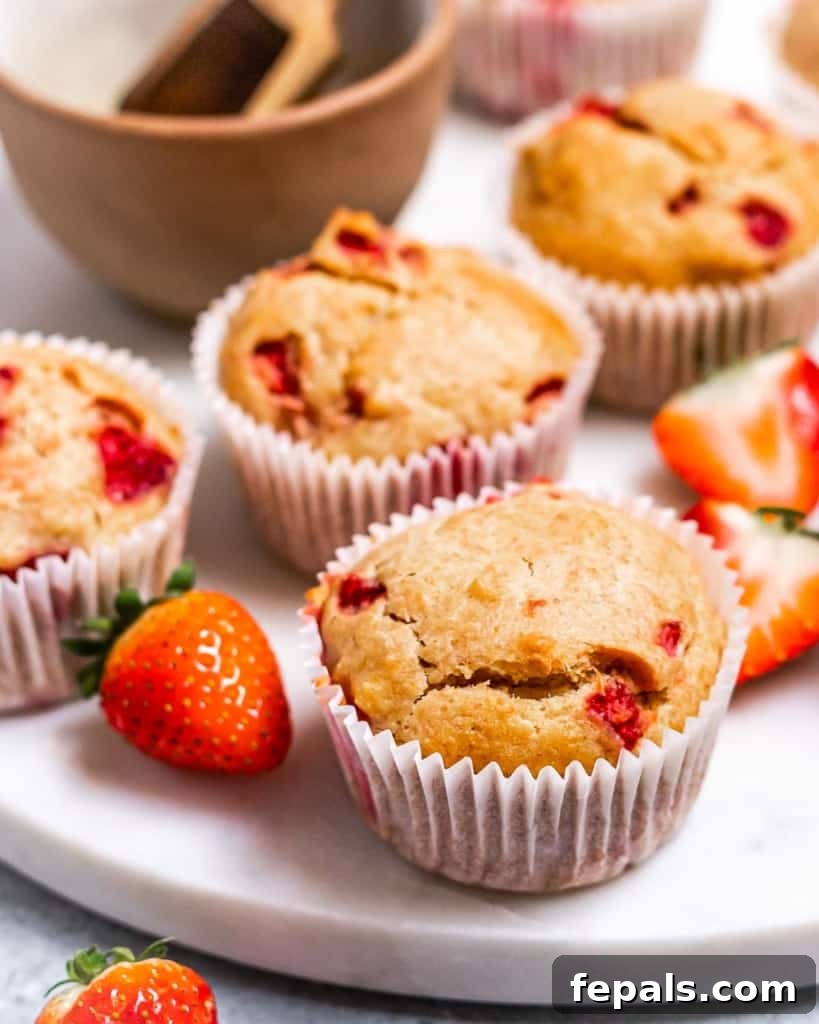 Wholesome Strawberry Muffins 8 A close-up side shot of muffins on a white round plate, highlighting their texture.