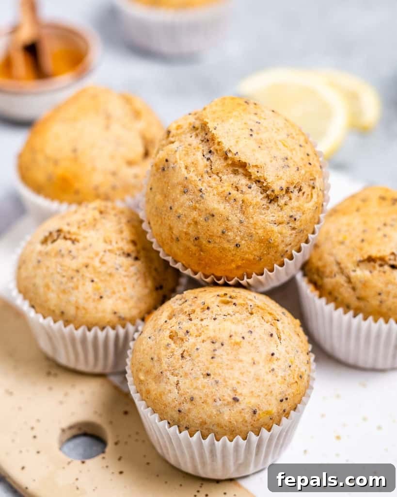 A beautiful stack of perfectly golden and fluffy lemon poppy seed muffins, inviting and ready to be served and enjoyed.