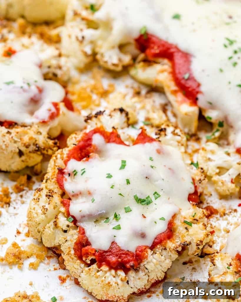 side shot of baked parmesan cauliflower steaks topped with melted cheese