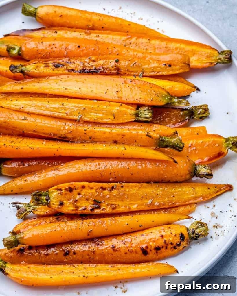 Honey-Kissed Balsamic Roasted Carrots 3 Roasted carrots on a white plate.