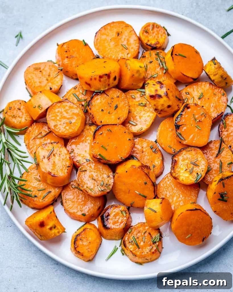 Caramelized Sweet Potatoes 8 A single perfectly roasted sweet potato round on a white plate, showcasing its golden color and caramelized edges.