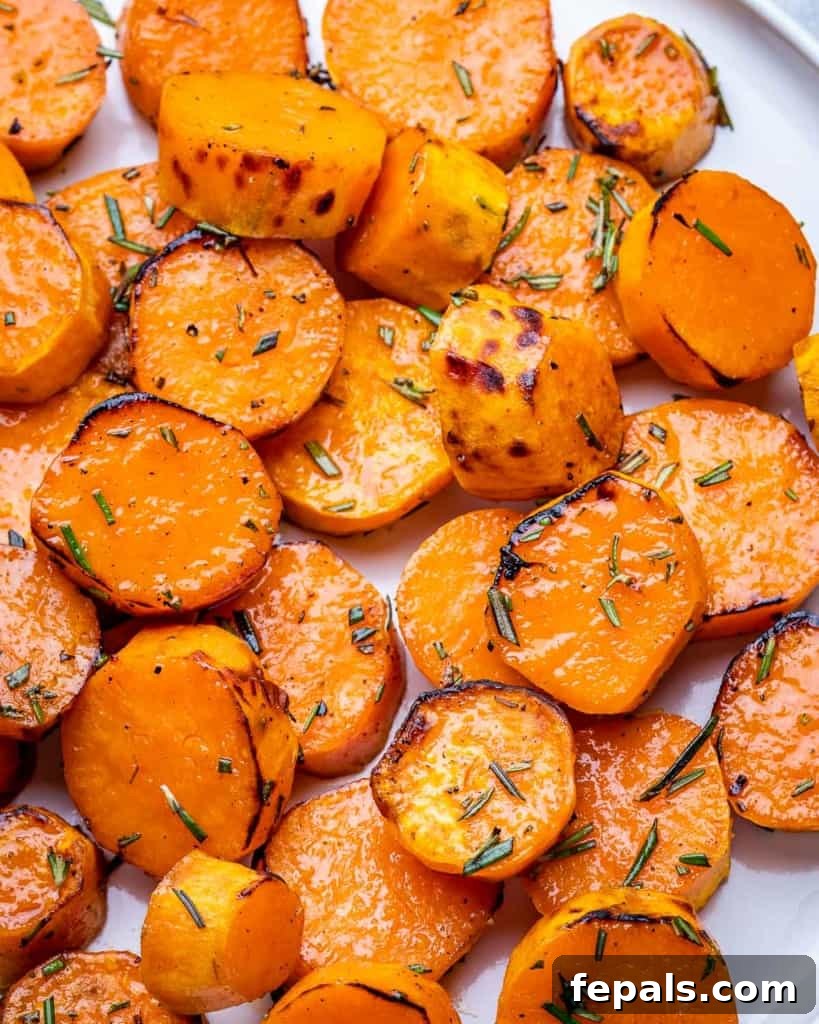 Caramelized Sweet Potatoes 10 Browned roasted sweet potato rounds garnished with fresh rosemary, artfully arranged.
