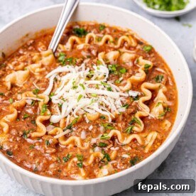 Hearty Lasagna Soup 12 side shot of lasagna soup in a white bowl with spoon in it