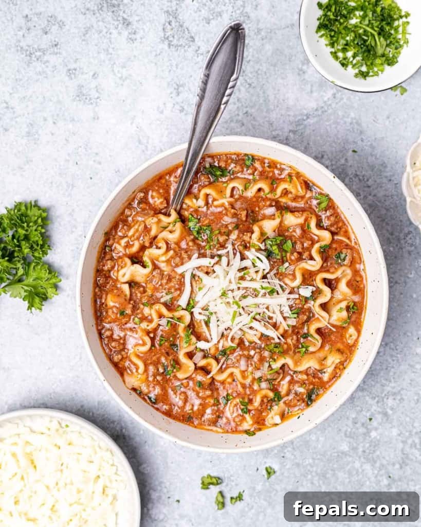 Hearty Lasagna Soup 3 A pristine white bowl of lasagna soup, generously topped with melted mozzarella and fresh basil, showcasing its rich texture and appetizing appeal.