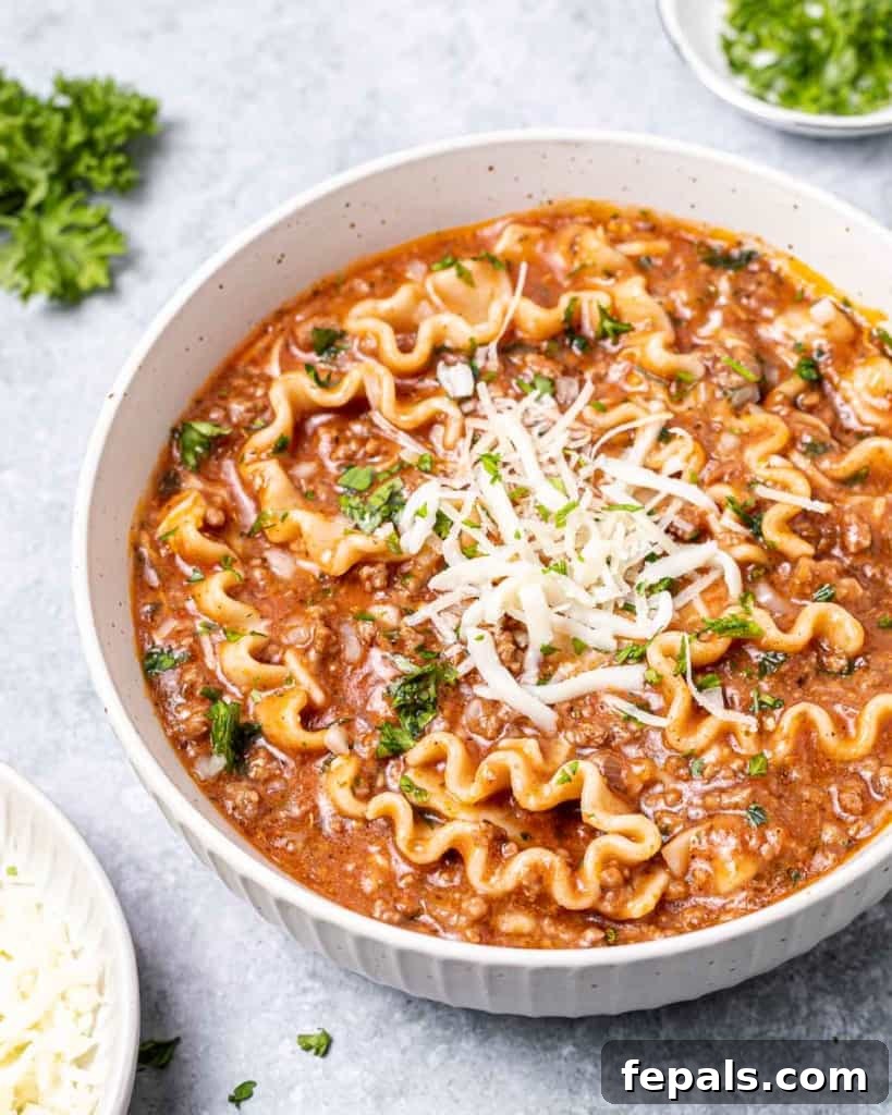 Hearty Lasagna Soup 10 A bowl of lasagna soup lavishly topped with fresh parsley and melted mozzarella cheese, creating an inviting and herbaceous garnish.