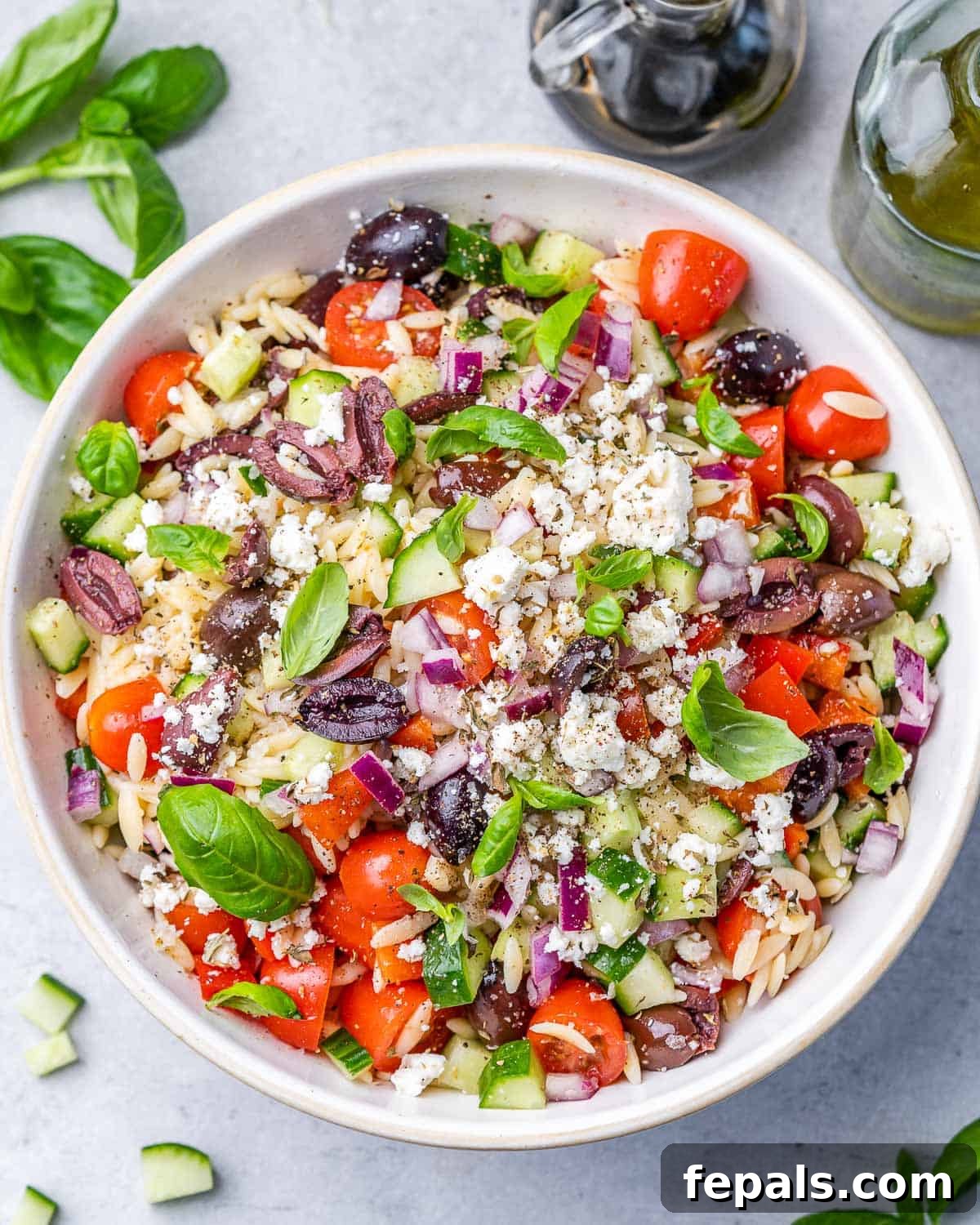 Zesty Greek Orzo Salad 8 Greek Orzo Pasta Salad, fully mixed with fresh veggies and herbs, presented in a large bowl.