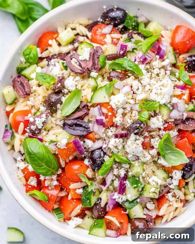 Zesty Greek Orzo Salad 9 Top view close-up of a perfectly mixed Greek Orzo Pasta Salad in a round white bowl, ready to be served.