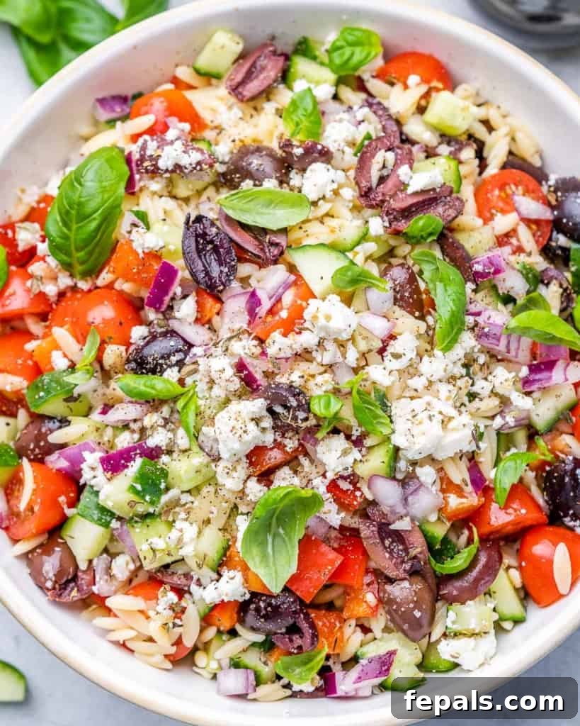 Zesty Greek Orzo Salad 10 Orzo pasta salad featuring fresh veggies, basil, and olives in a clean white bowl, showcasing its Mediterranean appeal.