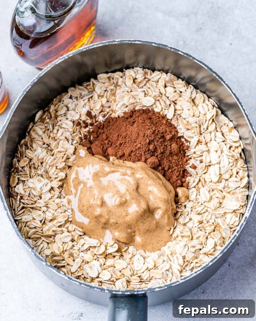 cocoa powder and peanut butter added to the cooked oatmeal in a pot