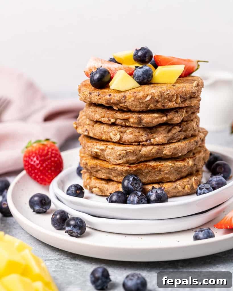 A stack of fluffy whole wheat pancakes topped with fruit.