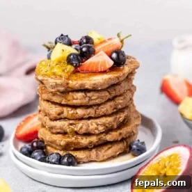 side shot of stacks of pancake topped with fruits