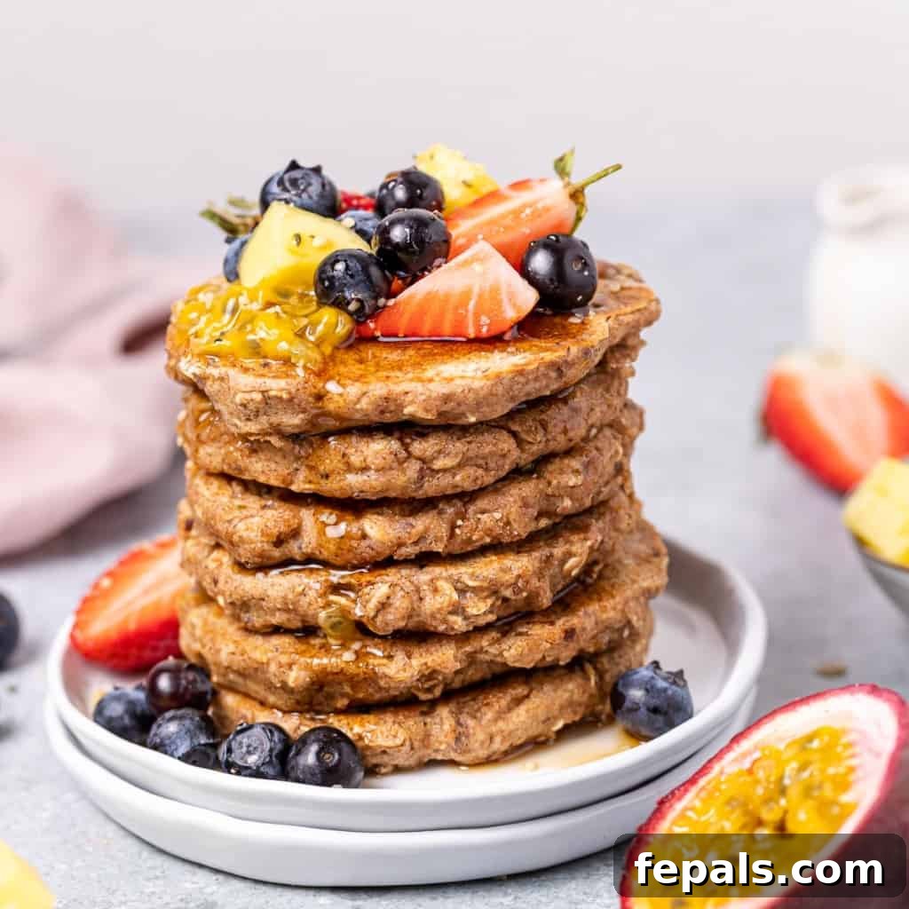 side shot of stacks of pancake topped with fruits