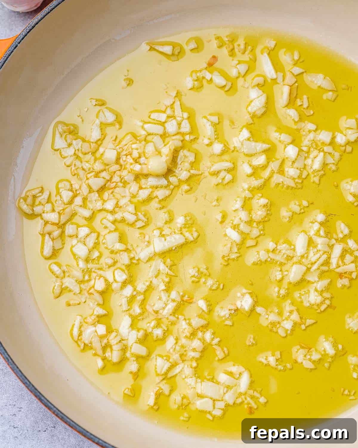 Luscious Vegan Lemon Pasta 6 Olive oil and chopped garlic gently cooking in a pan, creating an aromatic base.