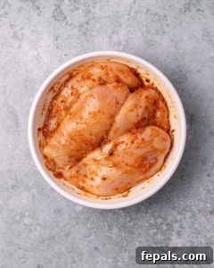 Skillet Peri Peri Chicken: Creamy & Zesty 17 Chicken marinating in a white bowl.