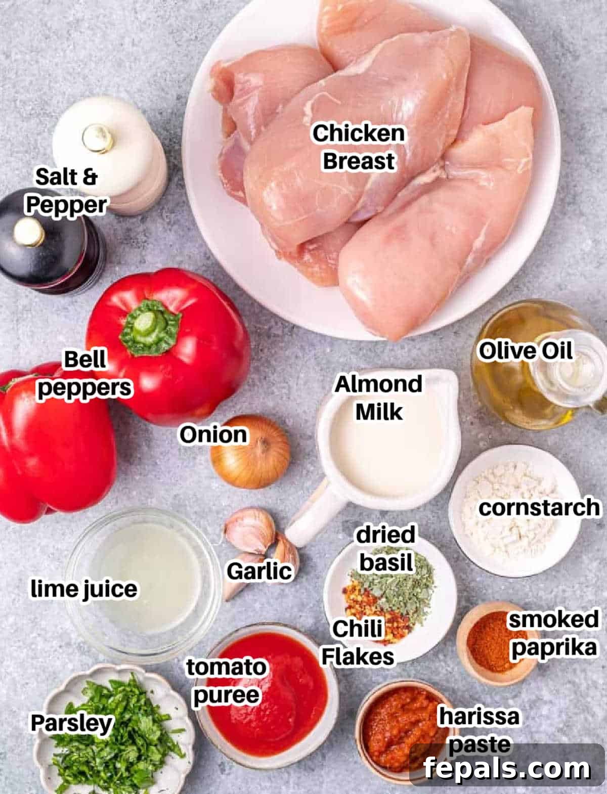 Skillet Peri Peri Chicken: Creamy & Zesty 5 A flat lay photograph showcasing all the fresh ingredients needed to make peri peri chicken, including chicken, bell peppers, onions, and various spices.