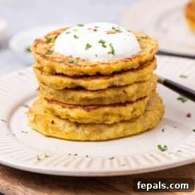 Side shot of stacks of potato pancakes on a plate topped with yogurt