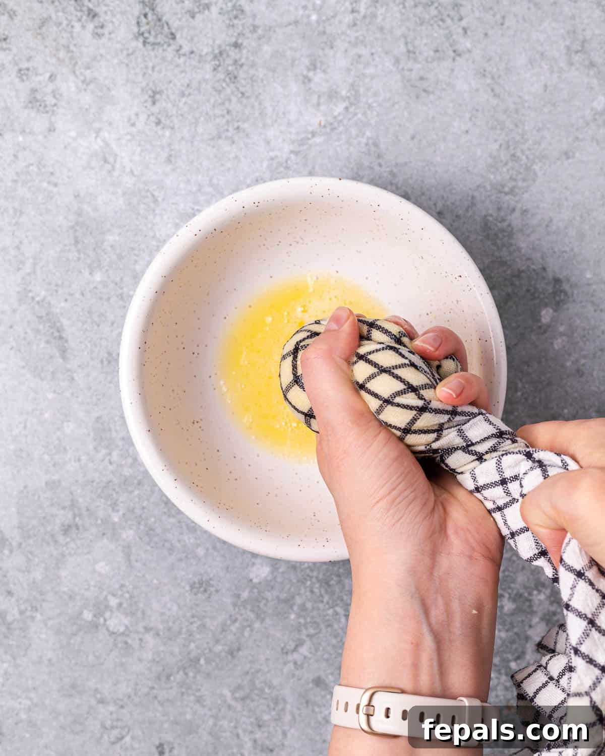 Timeless Golden Potato Fritters 7 Straining excess liquid from minced potatoes and onions using a fine-mesh strainer.