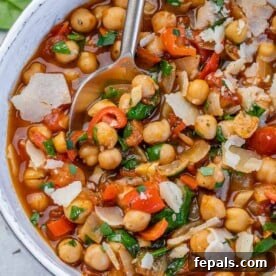 Savory Chickpea and Vegetable Simmer 13 chickpea stew in a white bowl with a spoon in it